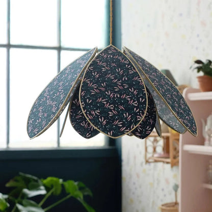 Decorative hanging lamp with leaf-like design in a room setting.